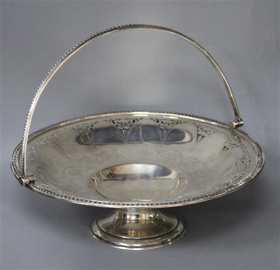 A Victorian engraved and pierced silver circular pedestal dish with swing handle, B.B, Sheffield, 1865,